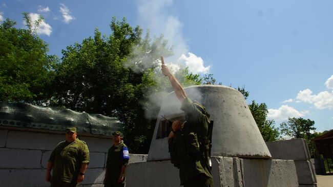 Военнослужащий ЛНР запускает сигнальную ракету белого цвета, означающую готовность ополченцев приступить к разведению сил и средств, на контрольно-пропускном пункте в районе Станицы Луганской