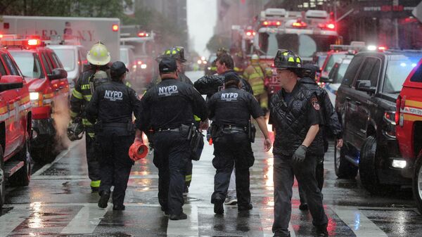 Сотрудники полиции и пожарные службы работают возле места крушения вертолета в Нью-Йорке