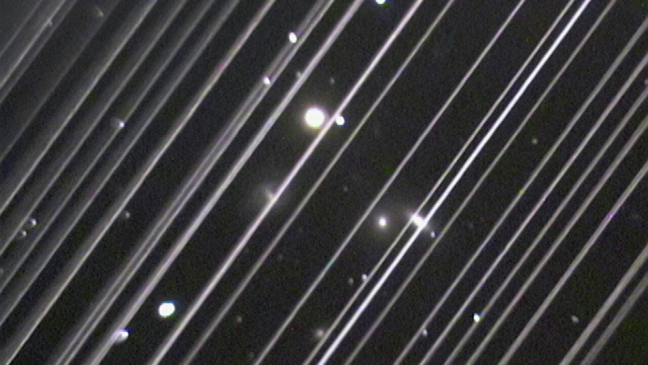 Фотография группы галактик NGC 5353/4 в созвездии Гончих Псов. Светлые линии на снимке – спутники системы Starlink - РИА Новости, 1920, 20.12.2022