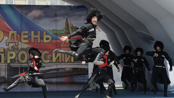 Участники ансамбля песни и танца Заманхо выступают на праздничном концерте, посвященном Дню России, на площади перед мечетью Сердце Чечни в Грозном