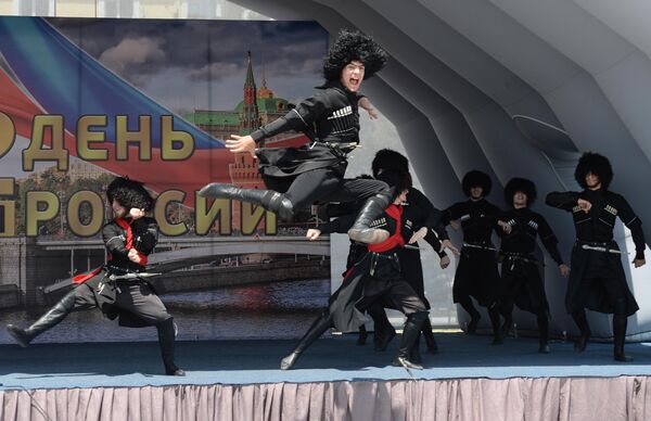 Участники ансамбля песни и танца Заманхо выступают на праздничном концерте, посвященном Дню России, на площади перед мечетью Сердце Чечни в Грозном