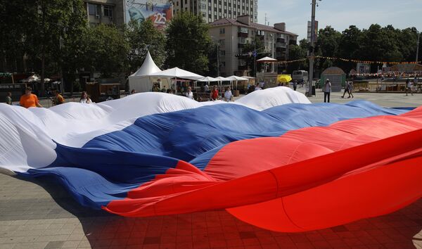 Участники флэшмоба Я люблю Россию развертывают огромный триколор на Главной городской площади в Краснодаре