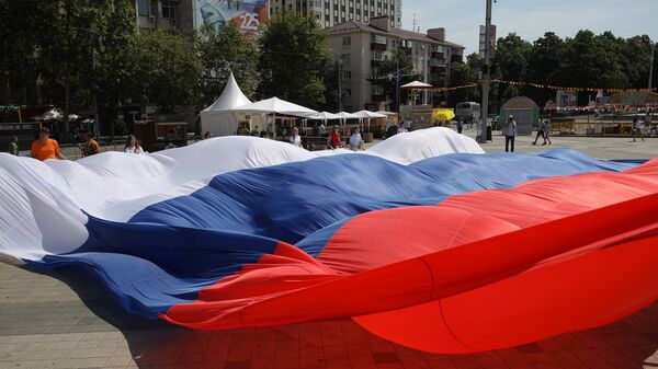 Участники флэшмоба Я люблю Россию развертывают огромный триколор на Главной городской площади в Краснодаре