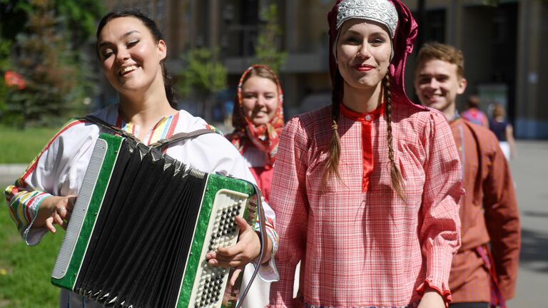 Молодые люди в национальных костюмах на Параде дружбы народов в парке им. М. Горького в Казани