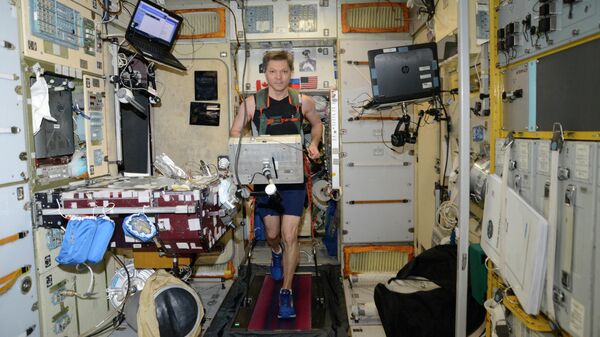 Российский космонавт Олег Кононенко бегает на российской дорожке БД-2 в модуле Звезда на МКС