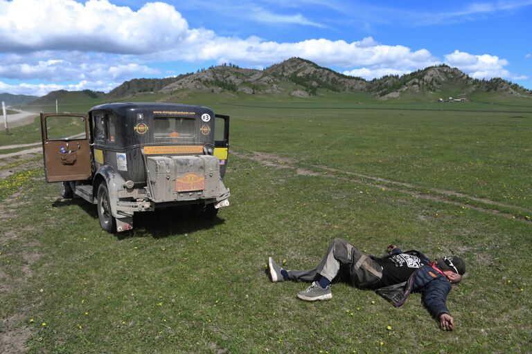 Участник международного ралли на старинных автомобилях Пекин - Париж 2019 на автомобиле Ford Model A (1930 г.) во время остановки на точке контроля времени в Республике Алтай