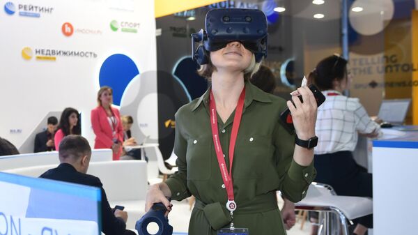 Посетительница в очках виртуальной реальности на стенде МИА Россия сегодня