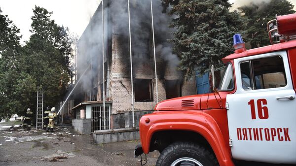 Машина пожарной службы МЧС рядом с горящим зданием в поселке Горячеводском в Пятигорске