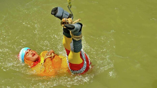 Индийский иллюзионист Чанчал Лахири во время исполнения трюка в Калькутте. 16 июня 2019