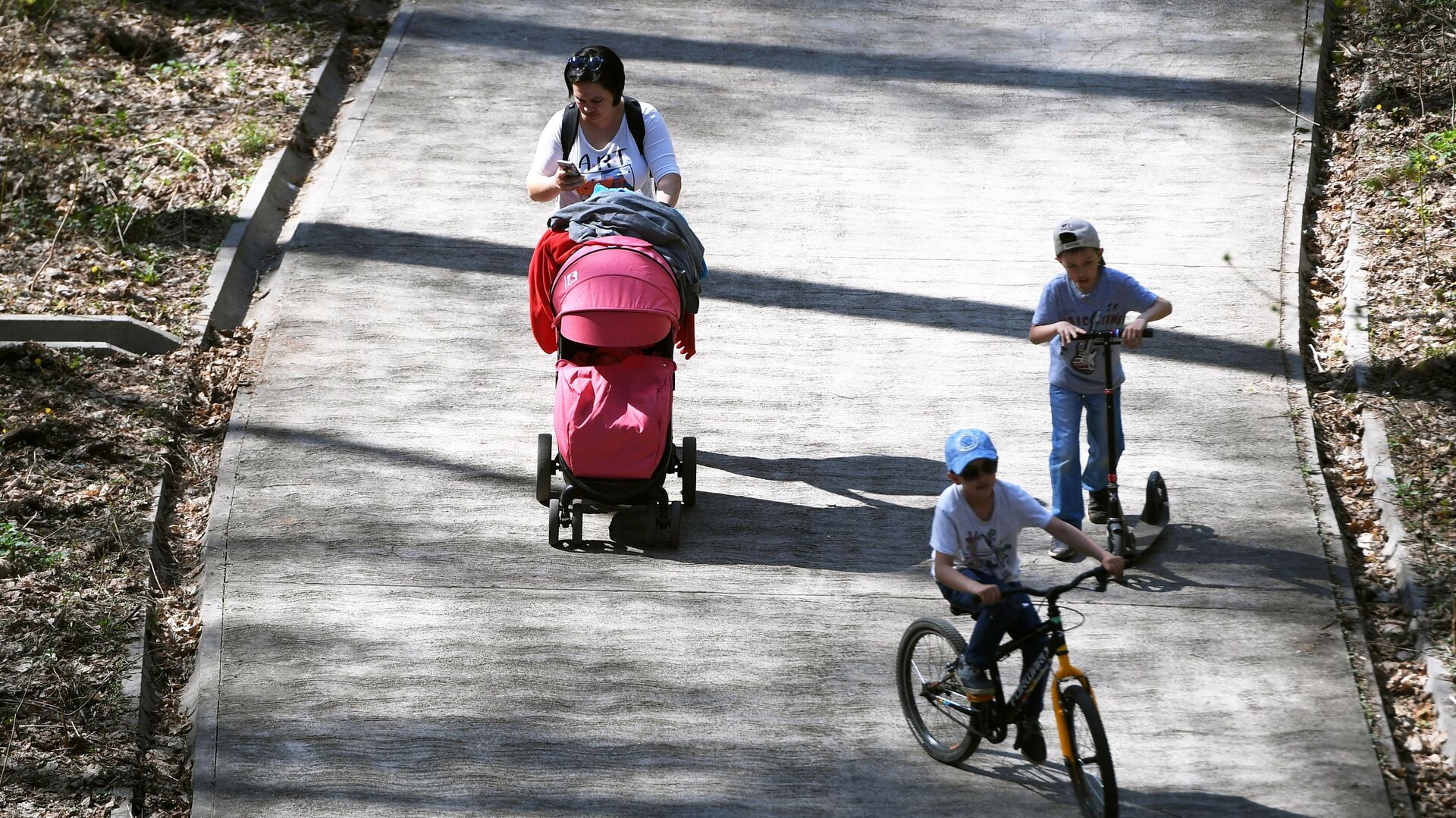 Женщина гуляет с детьми в парке - РИА Новости, 1920, 21.03.2024