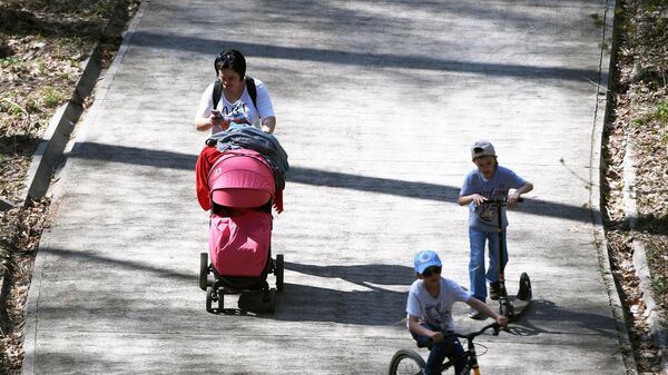 Женщина гуляет с детьми в парке