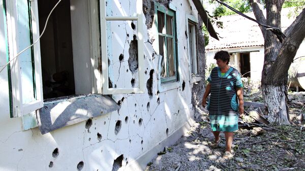 Женщина у жилого дома в поселке Новая Марьевка в Донецкой области, пострадавшего в результате ночного обстрела. 9 июня 2019