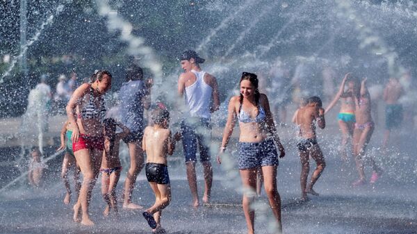 Горожане спасаются от жары в фонтане парка 300-летия Санкт-Петербурга. Архивное фото