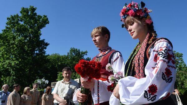 Горожане в национальных костюмах возлагают цветы к памятнику поэта Тараса Шевченко