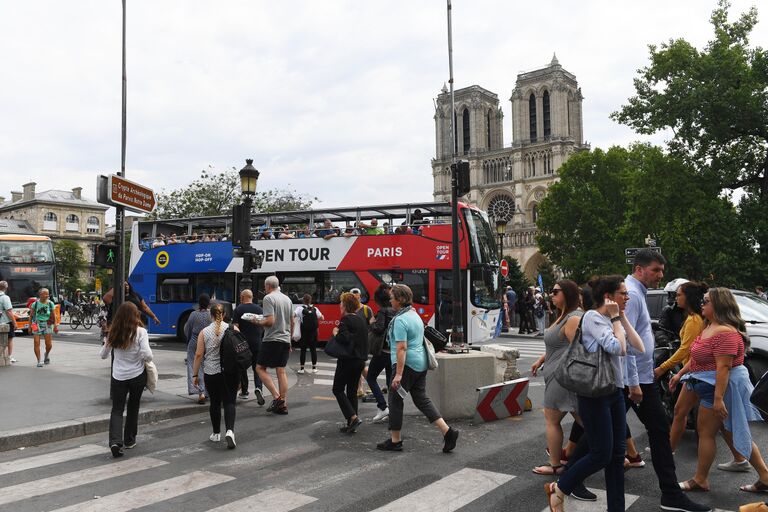 Горожане и туристы на площади у Собора Парижской Богоматери (Notre Dame de Paris) в Париже