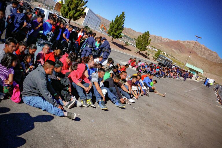 Мигранты, задержанные после пересечения мексиканской границы в Эль-Пасо Мигранты, задержанные после пересечения мексиканской границы в Эль-Пасо