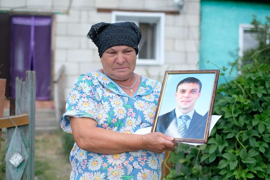 Мать убитого Владимира Грушина держит в руках его фото