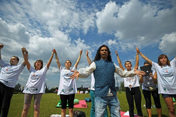 Учитель медитации в традиции кундалини тантра йоги Шива Гириш (на первом плане) вместе с участниками во время V Международного фестиваля йоги в парке Зарядье
