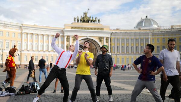 Туристы играют в мяч на Дворцовой площади в Санкт-Петербурге
