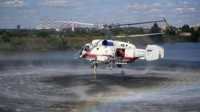 Пожарно-спасательный вертолет Ка-32А осуществляет забор воды на показательном тушении пожара  в Москве