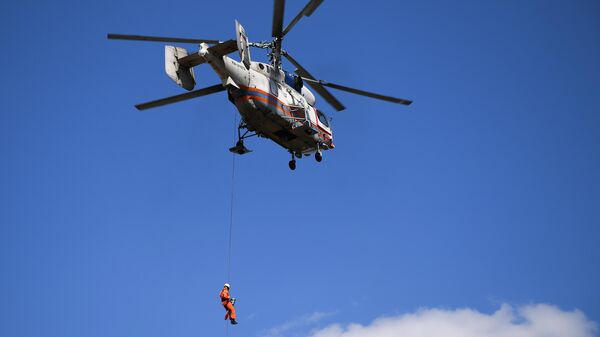 Спасатель-медик спускается на тросе с вертолета Ка-32А МАЦ во время учений