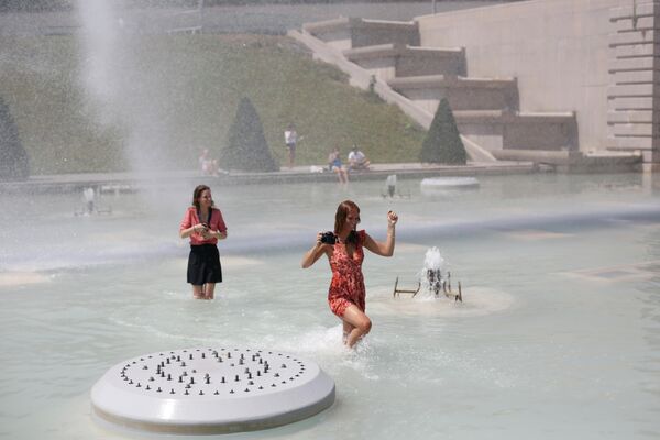 Женщины купаются в фонтане Трокадеро в Париже