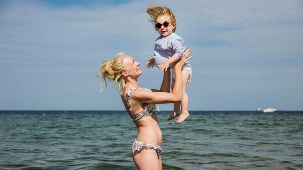 Женщина с ребенком купаются на Амагерском пляже в Копенгагене, Дания