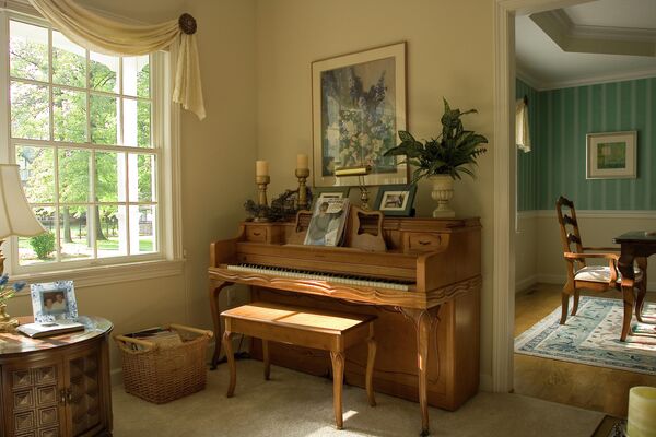 Интерьер гостиной комнаты с фортепиано и телевизором. Современный минимализм