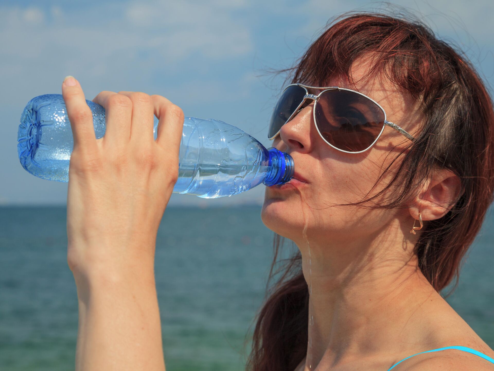 Жара пейте воду. Девушка пьет воду из бутылки. Девушка пьет из бутылки. Девушка из воды. Пить из пластиковой бутылки.