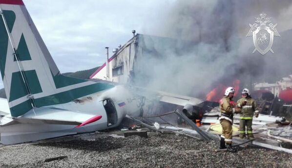 Сотрудники противопожарной службы тушат пожар на месте аварийной посадки самолёта Ан-24 в Нижнеангарске. Стоп-кадр с видео, предоставленного СК РФ