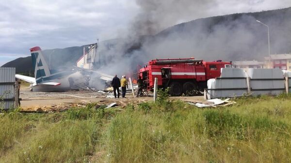 Сотрудники противопожарной службы тушат пожар на месте аварийной посадки самолёта Ан-24 в Нижнеангарске