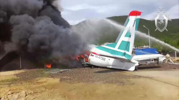 Сотрудники противопожарной службы тушат пожар на месте аварийной посадки самолёта Ан-24 в Нижнеангарске