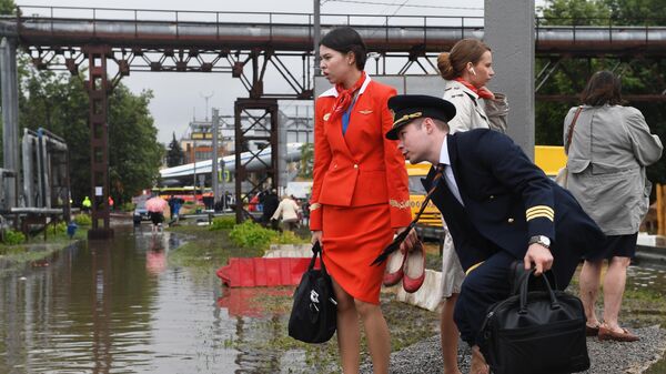 Сотрудники кампании ОАО Аэрофлот- российские авиалинии на затопленной улице в районе аэропорта Шереметьево