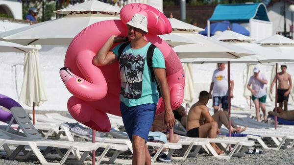 Мужчина с надувным кругом на пляже в районе Адлер города Сочи