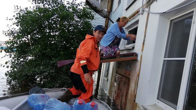 Сотрудники МЧС доставляют питьевую воду жителям подтопленного населенного пункта. 30 июня 2019