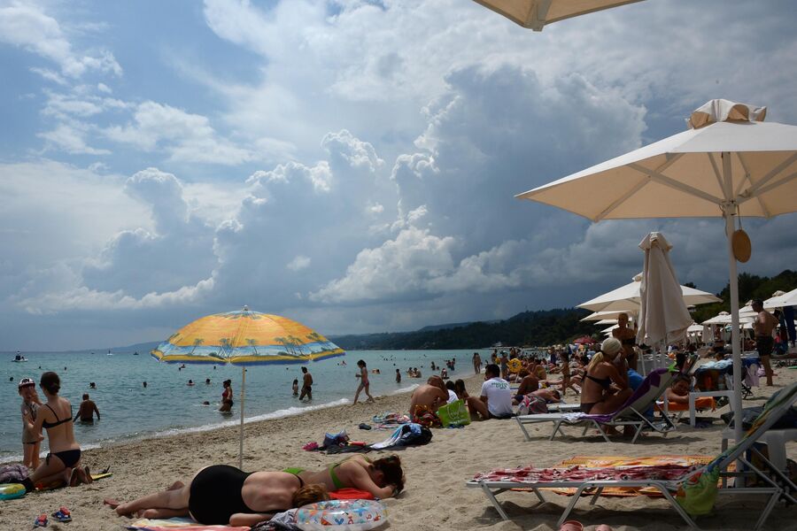 Отдыхающие на пляже полуострова Халкидики в Греции