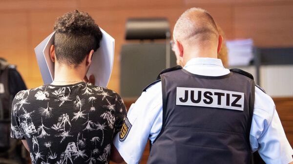 Один из обвиняемых в групповом изнасиловании 18-летней девушки в зале суда во Фрайбурге, Германия. 26 июня 2019