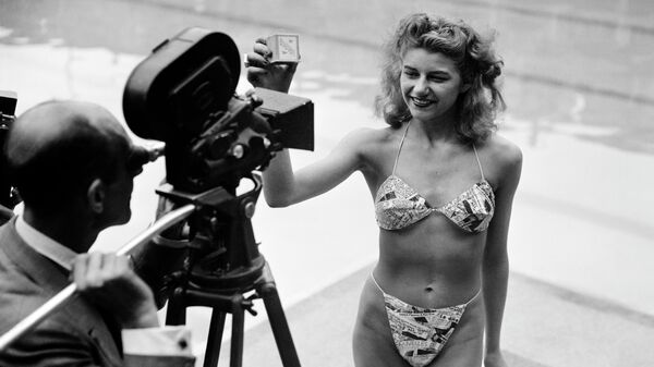 Девушка позирует в бикини в бассейне в Париже. 5 июля 1946 года