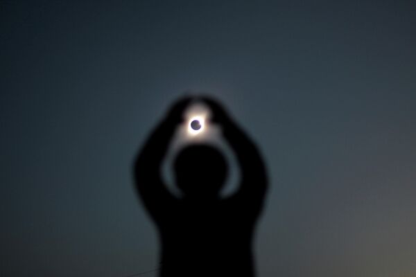 Человек во время солнечного затмения в Инкахуаси, Чили