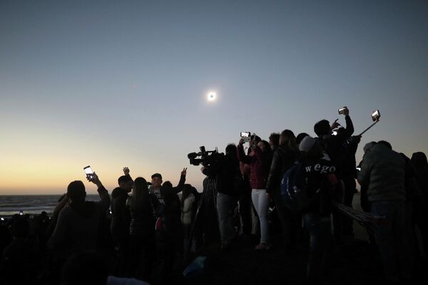 Люди наблюдают солнечное затмение в Ла Серена, Чили