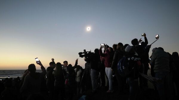 Люди наблюдают солнечное затмение в Ла Серена, Чили