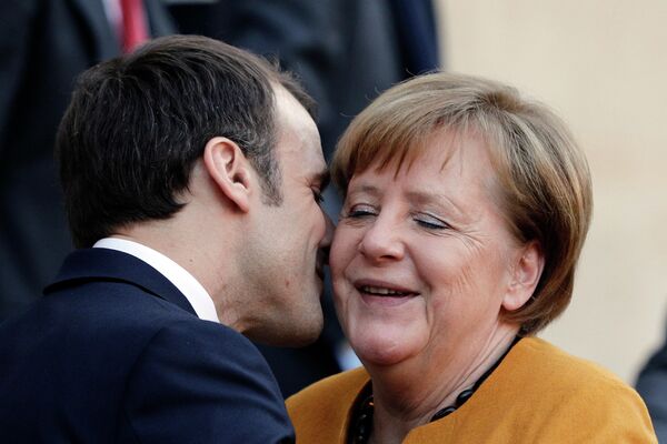 Президент Франции Эммануэль Макрон целует канцлера Германии Ангелу Меркель