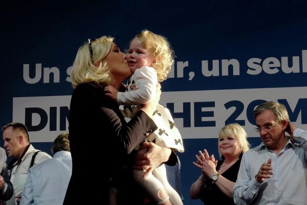 Марин ле Пен целует девочку во время предвыборного митинга в Анени-Бомоне