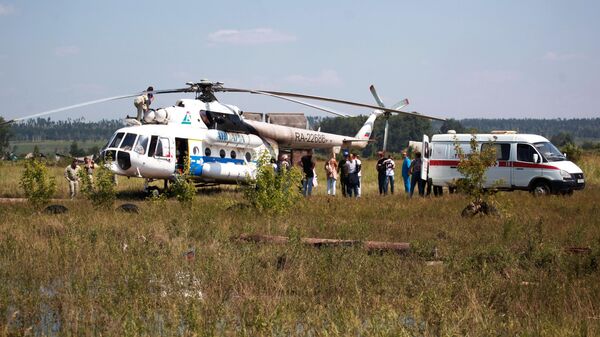 Вертолет Ми-8АМТ с медицинским модулем на борту и машина скорой помощи в Тулунском районе Иркутской области, где происходит ликвидация последствий паводка