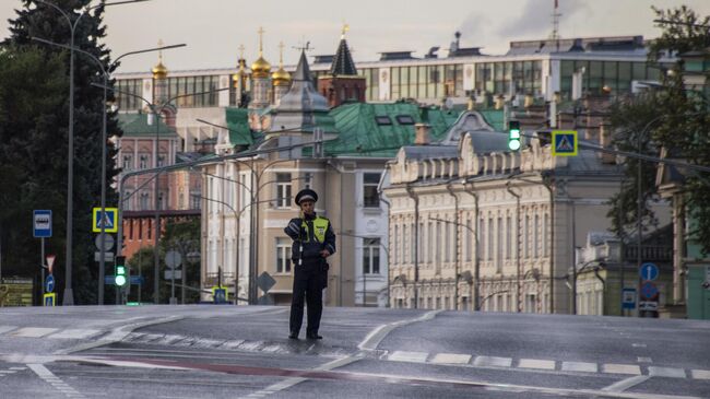 Сотрудник дорожно-патрульной службы у пешеходного перехода на улице Волхонке в Москве