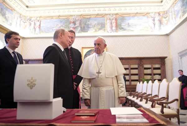  Президент РФ Владимир Путин и Папа Римский Франциск во время обмена подарками в Апостольской библиотеке в Ватикане