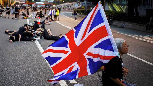 Женщина держит флаг Великобритании во время акции за отмену закона об экстрадиции в Гонконге 