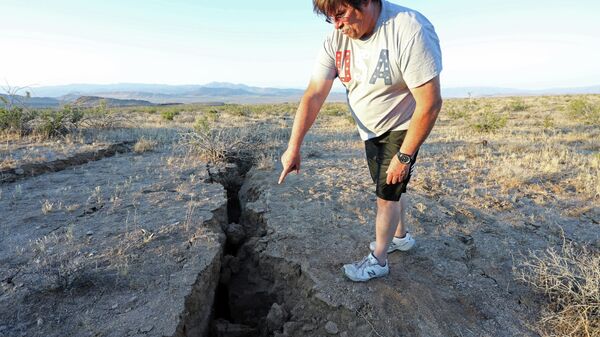 Мужчина смотрит на трещину в земле после мощного землетрясения в Калифорнии, недалеко от города Риджкрест, 4 июля 2019