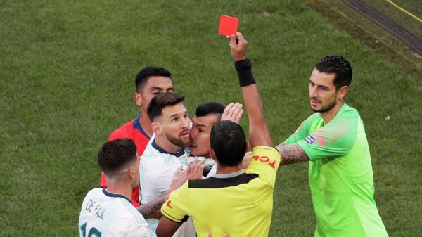 Капитан сборной Аргентины Лионель Месси (второй слева) получает красную карточку