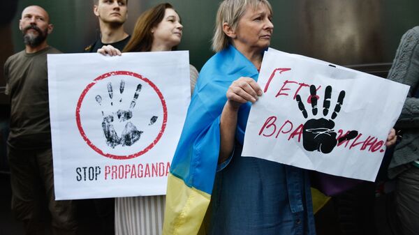 Участники акции протеста у офиса телеканала NewsOne против телемоста с российским каналом Россия 1